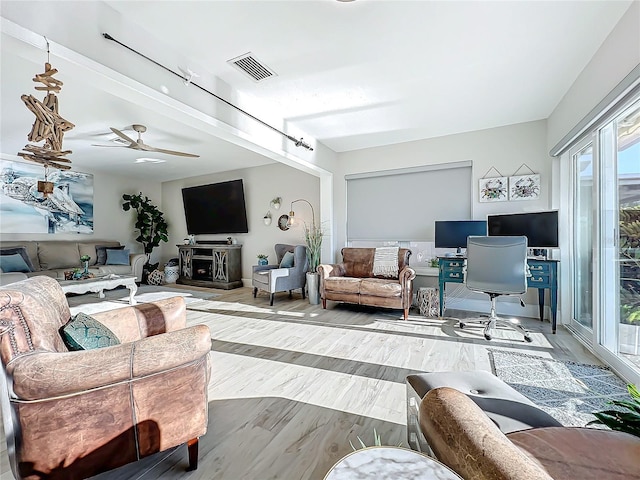 living room featuring ceiling fan and light hardwood / wood-style floors