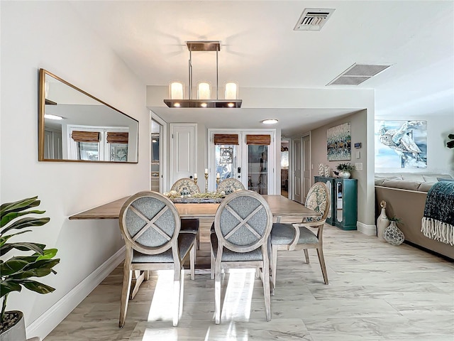 dining area with french doors and an inviting chandelier