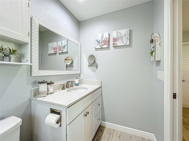 bathroom featuring hardwood / wood-style floors, vanity, and toilet