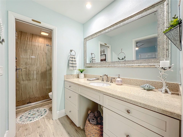 bathroom featuring hardwood / wood-style flooring, vanity, toilet, and an enclosed shower