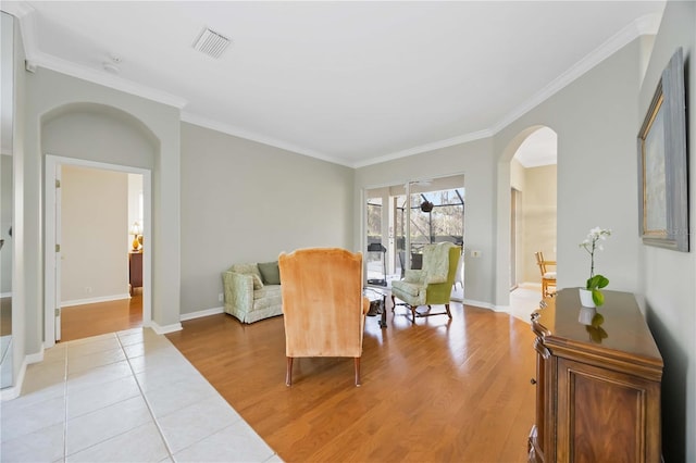 living area featuring crown molding and light hardwood / wood-style floors