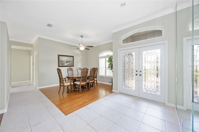 foyer entrance with ornamental molding, light tile patterned floors, ceiling fan, and french doors