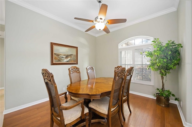 dining area with dark hardwood / wood-style flooring, crown molding, and ceiling fan