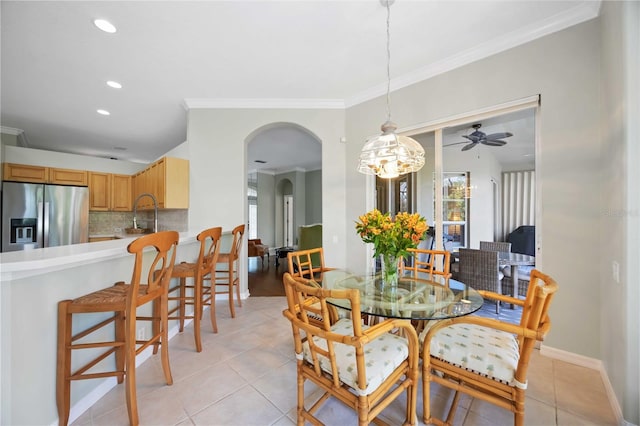 tiled dining space featuring ornamental molding and sink