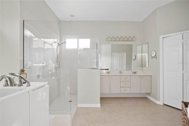 bathroom featuring vanity, a shower with shower door, and tile patterned flooring