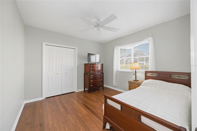 bedroom with dark wood-type flooring, ceiling fan, and a closet