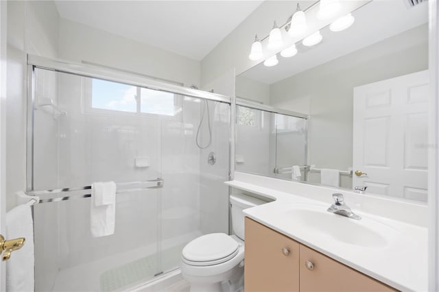 bathroom with walk in shower, vanity, and toilet