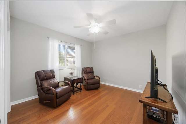 sitting room with hardwood / wood-style floors and ceiling fan