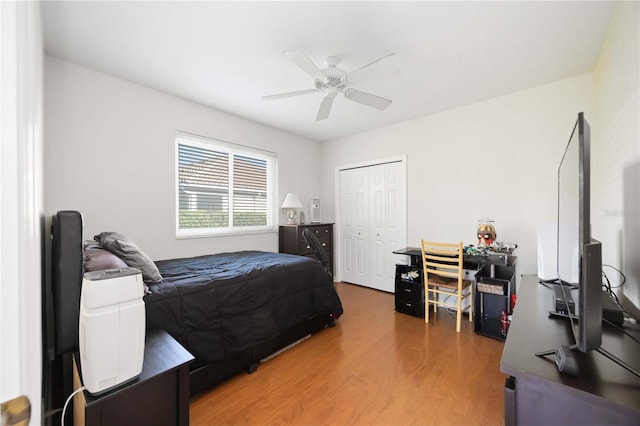 bedroom featuring light wood-style floors, ceiling fan, and a closet