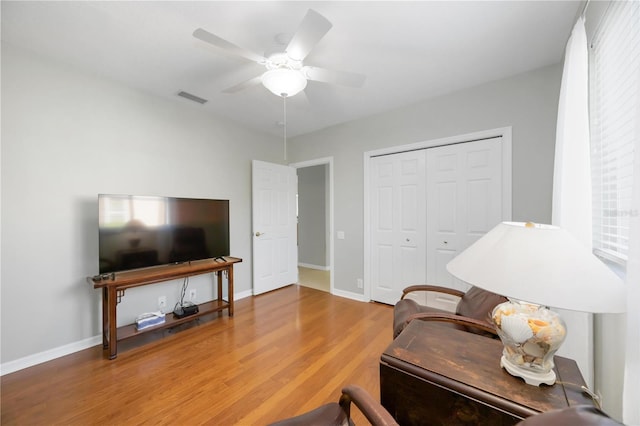 interior space with baseboards, wood finished floors, visible vents, and a ceiling fan