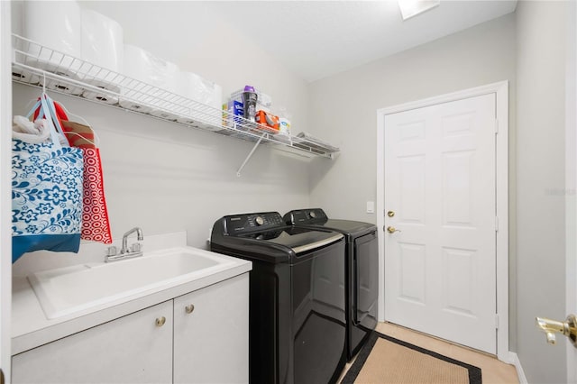 washroom with light tile patterned floors, washer and clothes dryer, and a sink