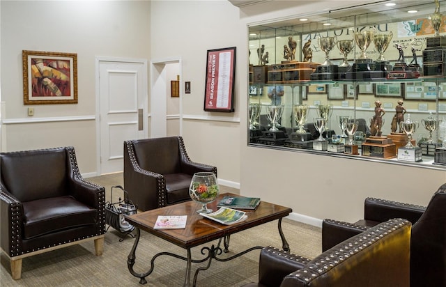 living area featuring carpet and baseboards