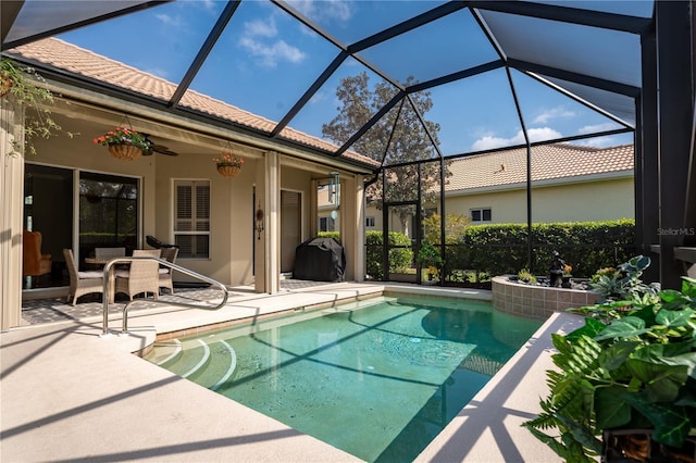 outdoor pool featuring a ceiling fan, a lanai, a patio area, and grilling area