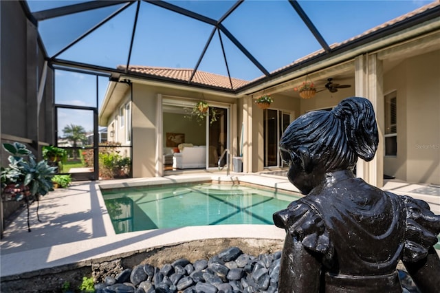 pool featuring ceiling fan, glass enclosure, and a patio area