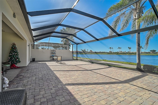 view of patio / terrace featuring a water view and a lanai