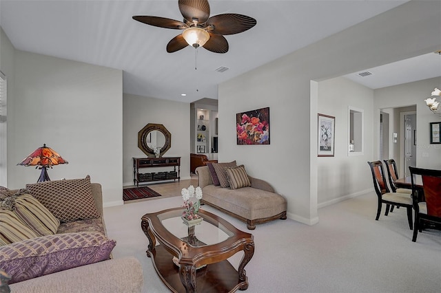 living room featuring light carpet and ceiling fan with notable chandelier