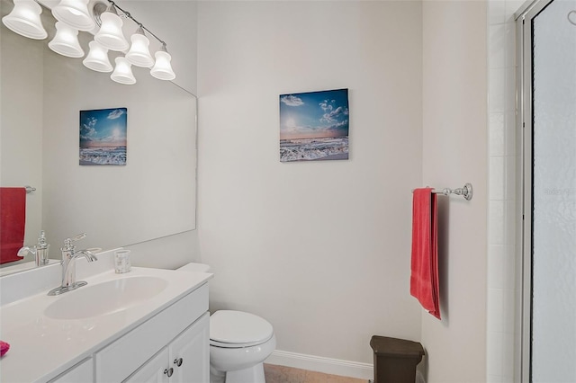 bathroom with vanity, a shower with shower door, and toilet