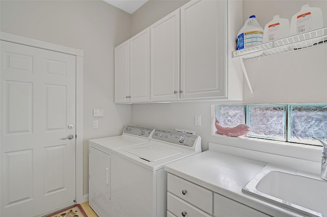 laundry area featuring washer and clothes dryer, sink, and cabinets