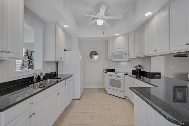 kitchen featuring white appliances, a raised ceiling, ceiling fan, sink, and white cabinets