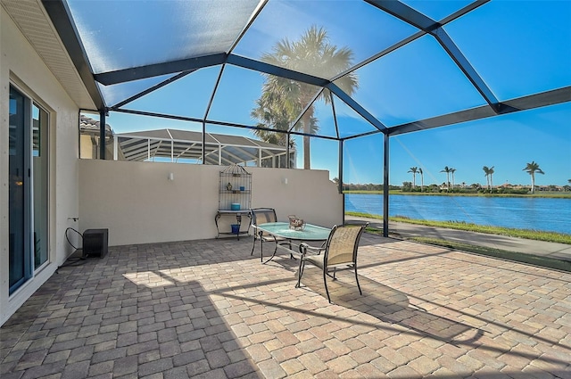 view of patio with a water view and glass enclosure