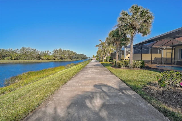 view of property's community with a lawn and a water view