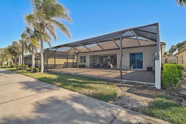 rear view of house with a lanai and a patio