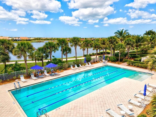 view of pool with a patio area and a water view