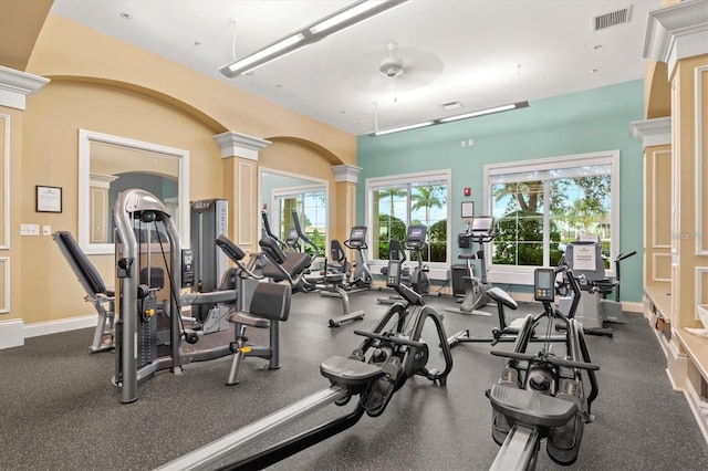 exercise room featuring decorative columns and ceiling fan