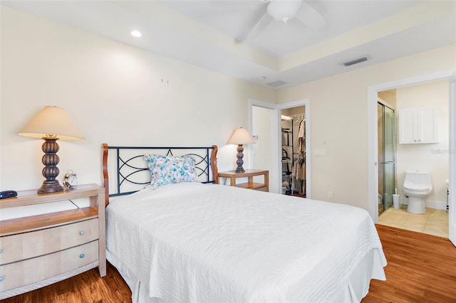 bedroom featuring connected bathroom, ceiling fan, a spacious closet, light hardwood / wood-style flooring, and a closet