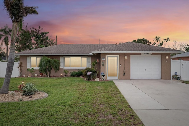 single story home with a garage and a lawn