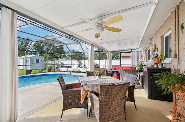 view of swimming pool featuring glass enclosure, a patio area, and ceiling fan