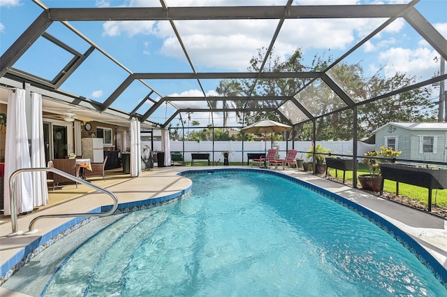 view of pool featuring glass enclosure, ceiling fan, and a patio area