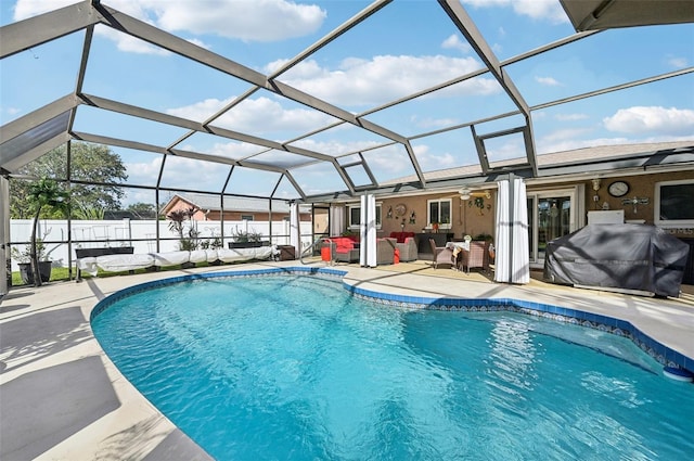 view of pool with an outdoor living space, ceiling fan, glass enclosure, a patio area, and a grill