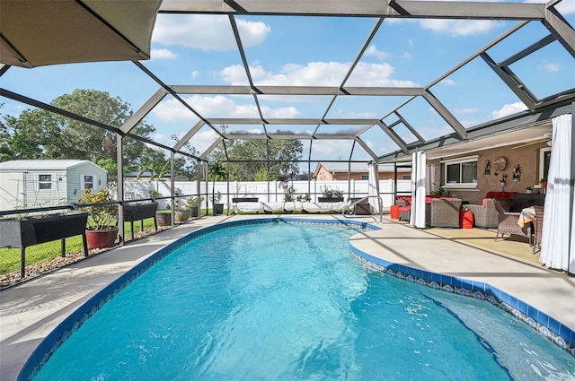 view of pool with a patio, a storage unit, and a lanai