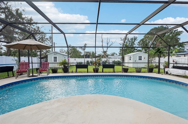 view of swimming pool featuring a yard, a shed, and a lanai