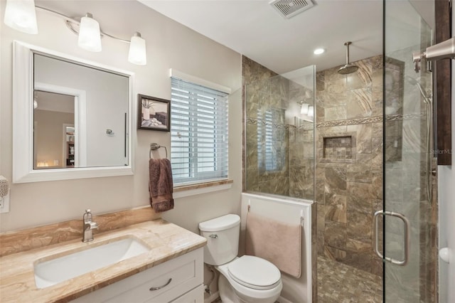 bathroom featuring vanity, toilet, and walk in shower