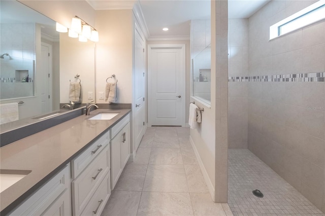 bathroom featuring a tile shower, tile patterned floors, vanity, and ornamental molding