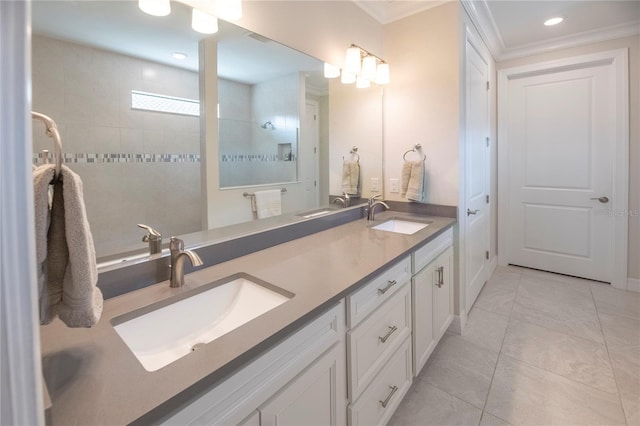 bathroom with vanity, ornamental molding, and tiled shower