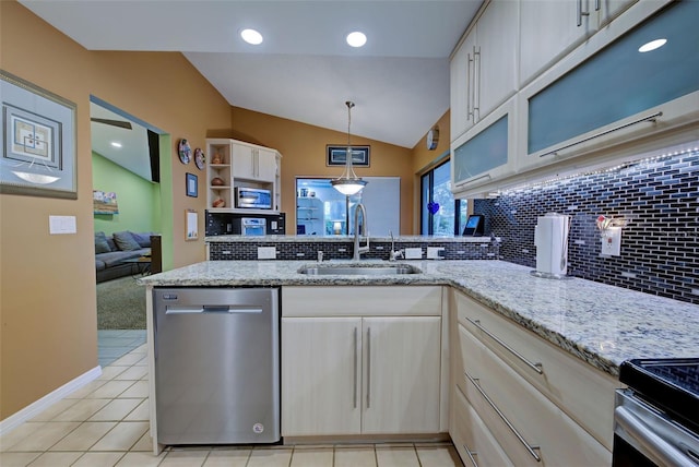 kitchen featuring dishwasher, sink, light stone counters, decorative light fixtures, and vaulted ceiling