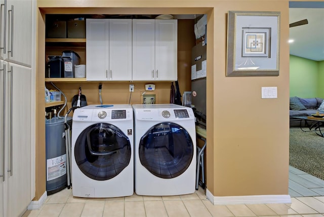 laundry area with cabinet space, independent washer and dryer, baseboards, and light tile patterned flooring