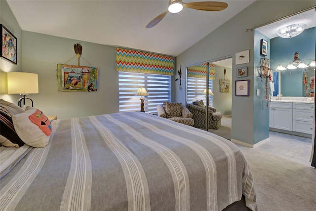 bedroom featuring ensuite bathroom, light colored carpet, vaulted ceiling, ceiling fan, and sink