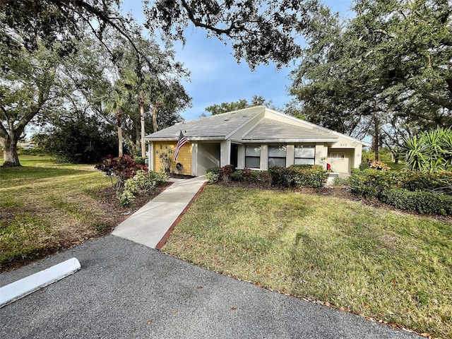 ranch-style home with a front yard and a tile roof