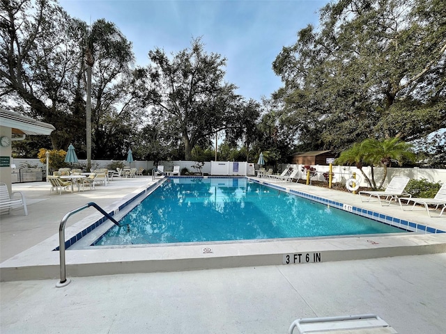 pool featuring fence and a patio