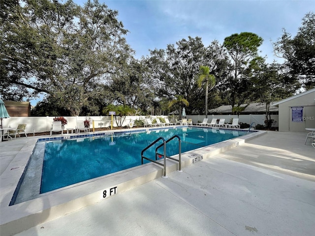 community pool with fence and a patio