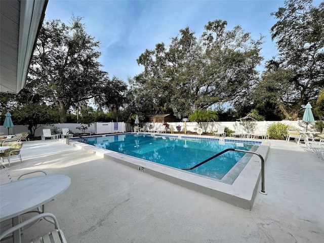 community pool featuring a patio and a fenced backyard