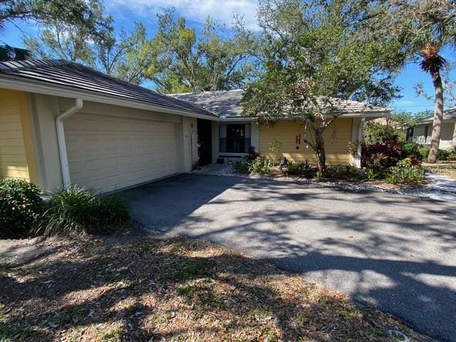 ranch-style house featuring aphalt driveway and an attached garage