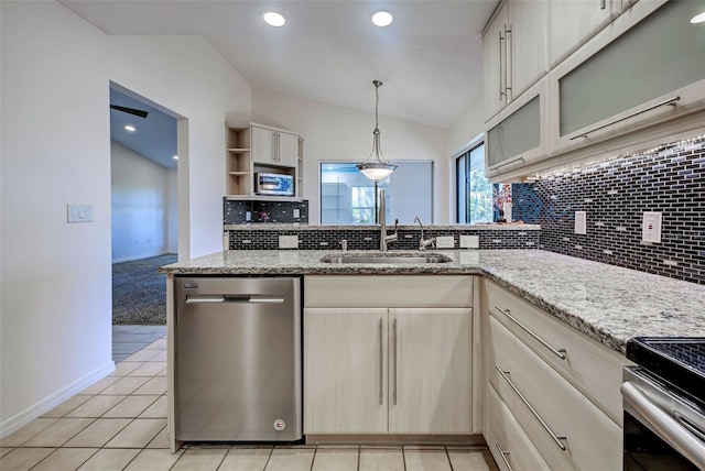 kitchen featuring tasteful backsplash, appliances with stainless steel finishes, lofted ceiling, and a sink