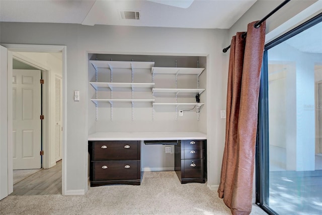 unfurnished office featuring visible vents, baseboards, and light carpet