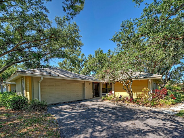 single story home with driveway, an attached garage, and stucco siding
