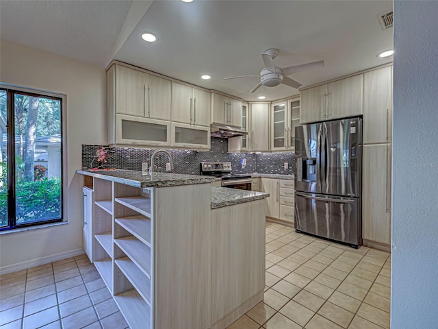 kitchen with stainless steel appliances, a peninsula, light tile patterned flooring, and decorative backsplash